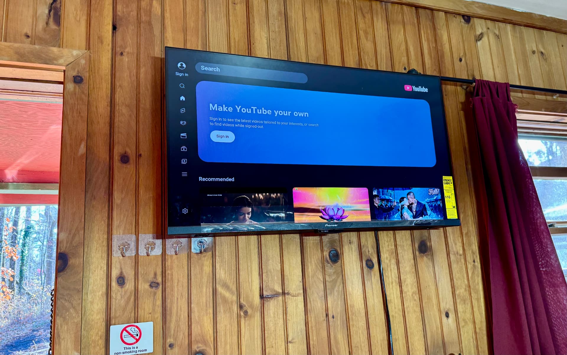 Wall-mounted smart TV in a wood-paneled cabin room