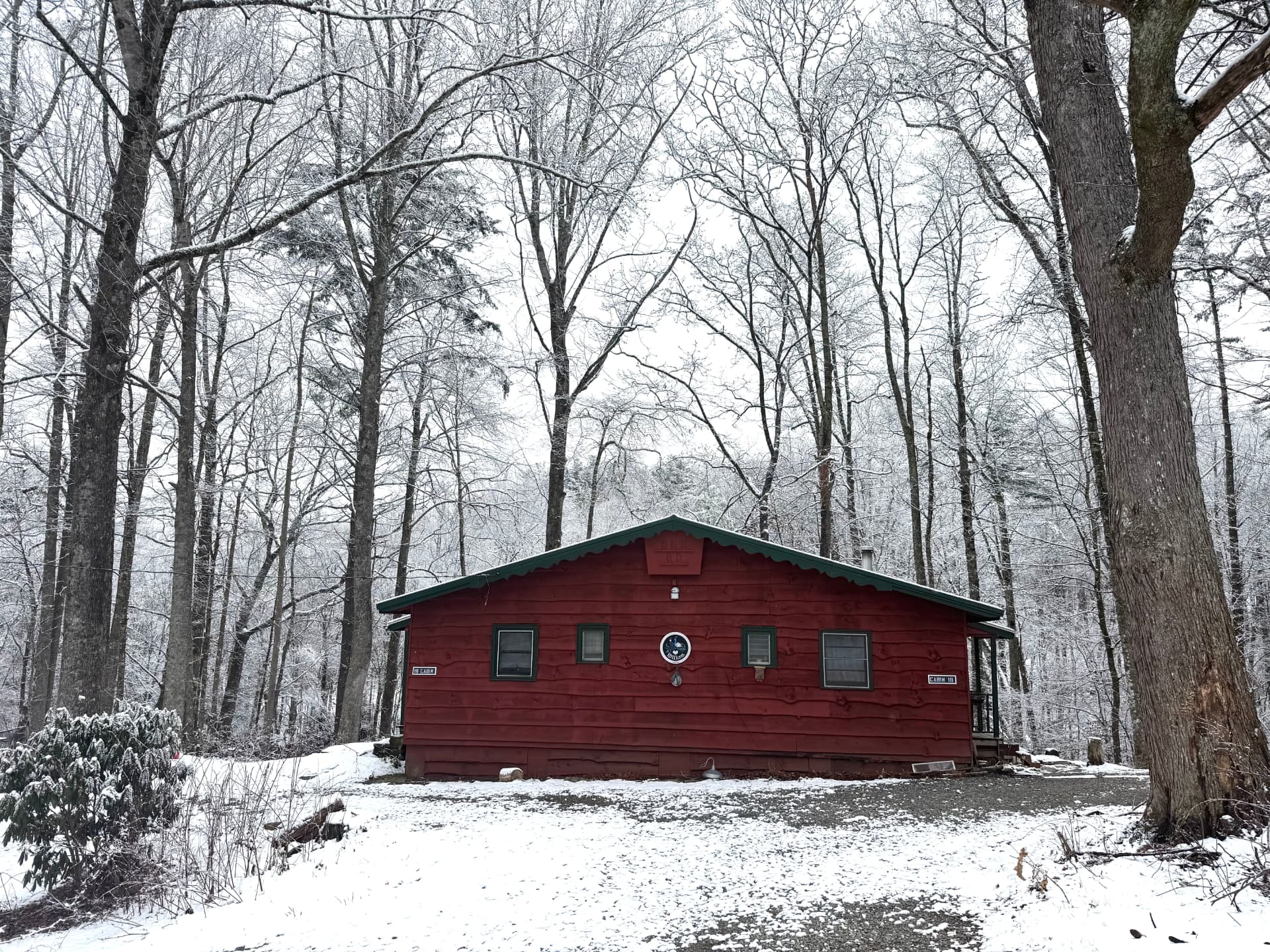 Cabin 111 with snow on the ground, framed by bare winter trees